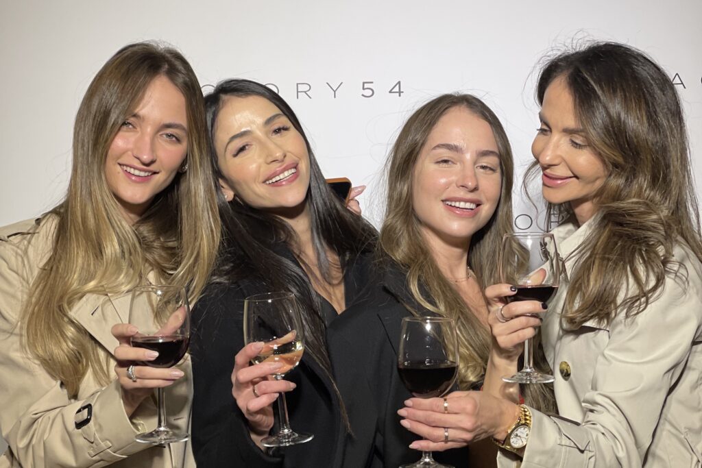 a few girls holding wine cups